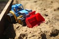 Warm spring little boy playing with toy cars in the sandbox. child boy playing car toy in sandbox outdoor Royalty Free Stock Photo